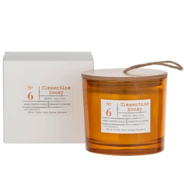 Candle labeled 'No. 6 Clementine Honey' with a matching box on a white background